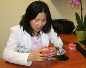 Dr. Cynthia Leung reviewing orthodontic treatment models at Caliper Orthodontics